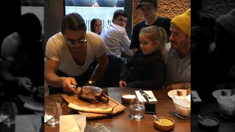 Nusret Gökçe, also known as Salt Bae, serves David Beckham and his children at Nusr-Et Steakhouse