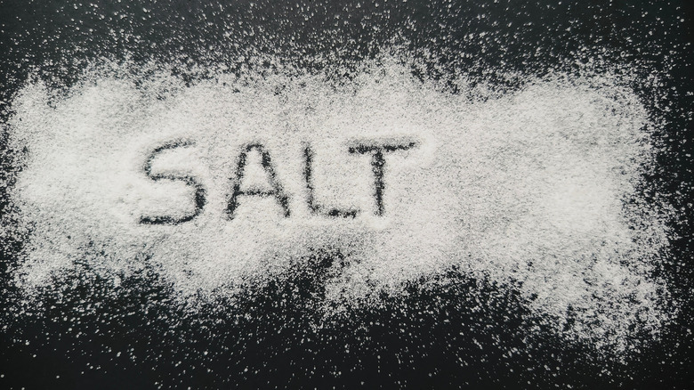 "SALT" traced on salt flakes scattered on a tabletop