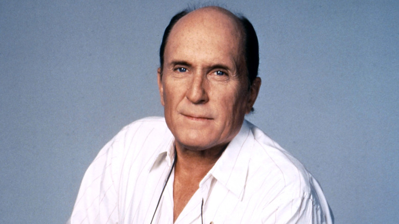 Robert Duvall smirking against blue background.