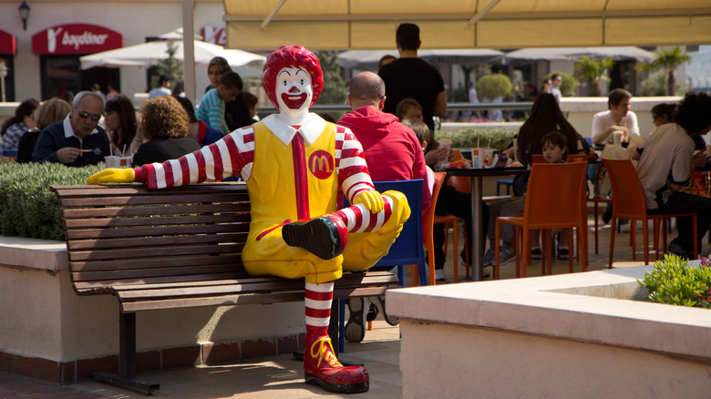 ronald mcdonald statue on park bench