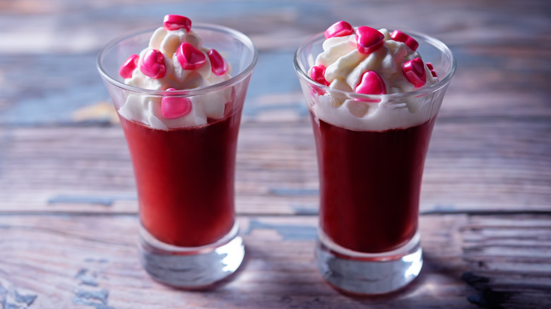A pair of Valentine's Day-themed Jell-O shots with whipped cream