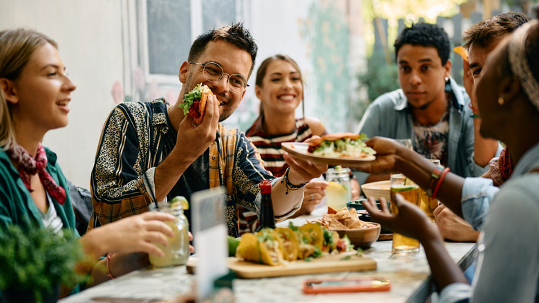 Young people enjoying tacos together