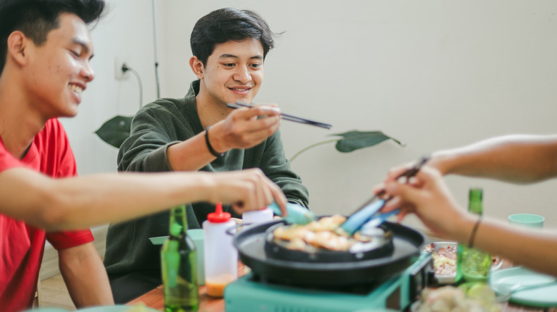 People dining around a Korean bbq grill