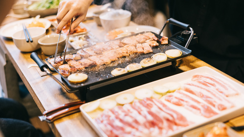 Pieces of meat being cooked at a Korean bbq