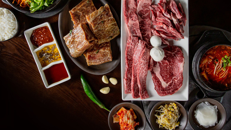 Overhead view of a spread of meats and sides at a Korean bbq restaurant
