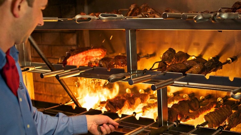 Fogo de Chao employee roasting meat