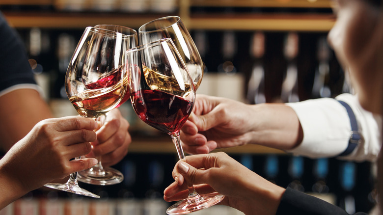 Four people toasting glasses of wine