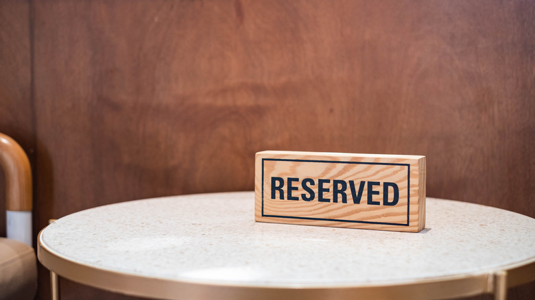A wooden reserved sign placed on a table