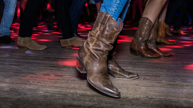 shot of peoples' legs and feet line dancing