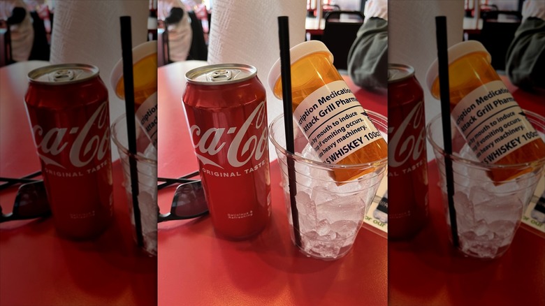 A can of Coke next to cup of ice