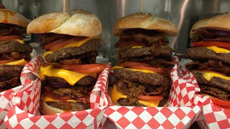 Four tall burgers in baskets