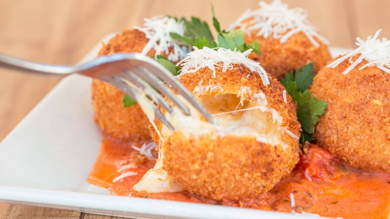 A fork spears into a fried macaroni and cheese ball at the Cheesecake Factory.