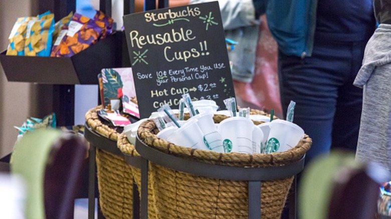 Basket of reusable Starbucks cups in the line at a store