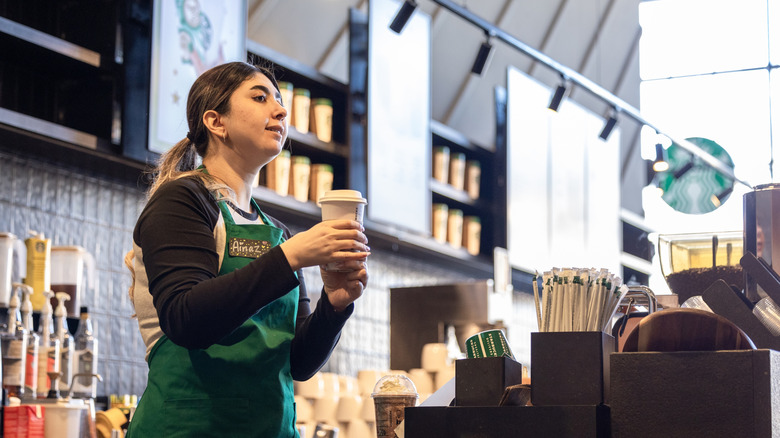 Starbucks barista serving coffee cup