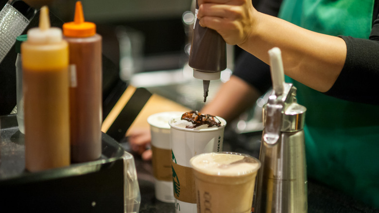 Starbucks Frappuccino and barista drizzling chocolate on hot drink