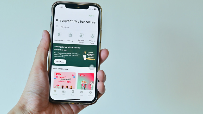Hand holding phone with Starbucks app