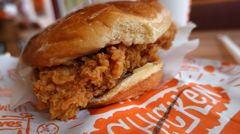 A closeup of an unwrapped Popeyes chicken sandwich