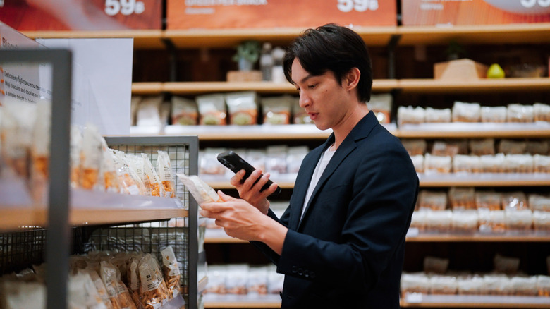 Man checking food label on phone