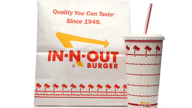 In-N-Out to-go bag alongside soda cup