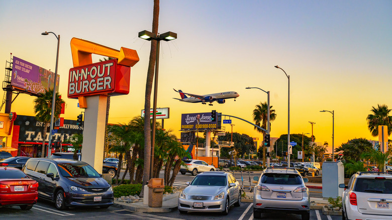 LAX In-N-Out's sign and parking lot at sunset