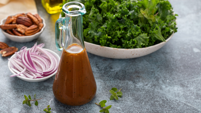 Homemade balsamic vinaigrette next to salad ingredients