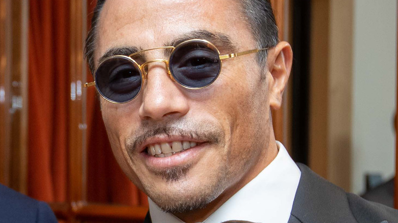 salt bae Nusret Gökçe smiles with sunglasses on