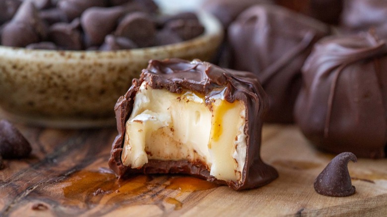 chocolate-coated brie cheese bite on wooden table