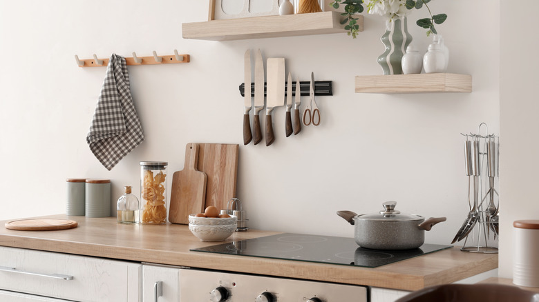 A cozy kitchen with various utensils and other types of kitchenware sitting on the counter.