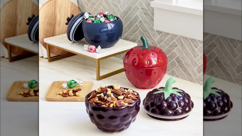 Three berry-shaped containers filled with various treats and snacks.