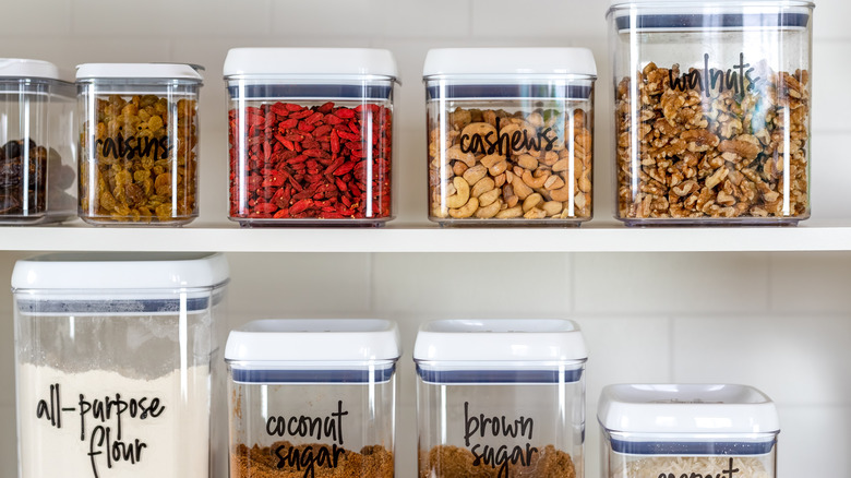 labeled food goods in clear containers in pantry