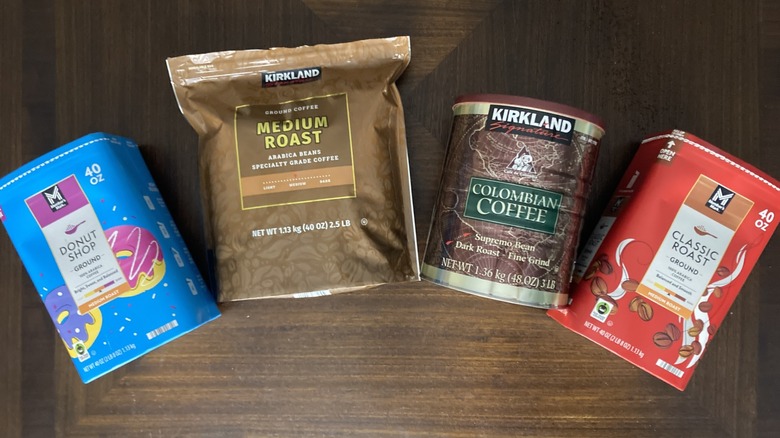 Costco and Sam's Club ground coffee packages on table, including Kirkland Signature medium roast and Member's Mark classic roast