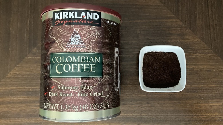 Canister of Kirkland Signature Colombian ground coffee next to ramekin of ground coffee