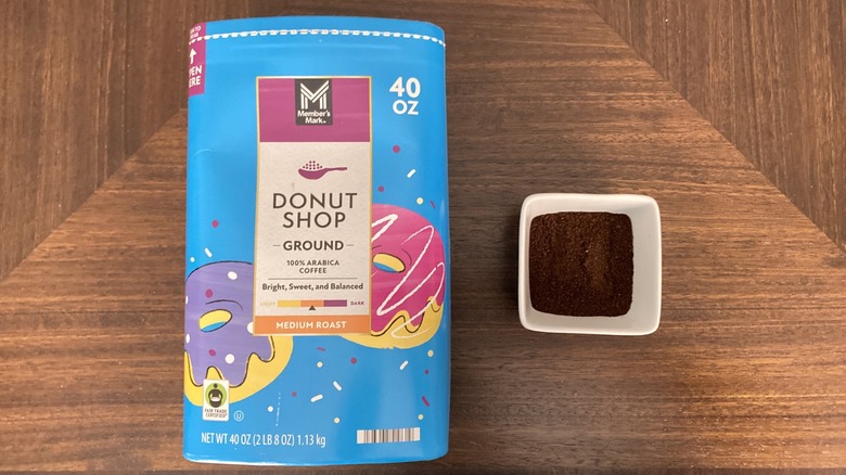 Sam's Club Donut Shop ground coffee in cardboard canister next to ramekin of coffee grounds