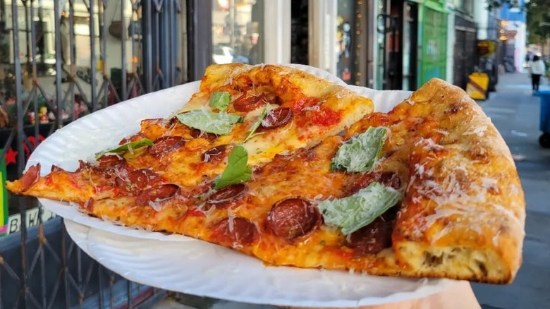 two slices of Outta Sight pizza on paper plates
