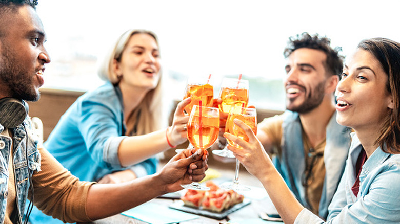 A group of friends toasting with cocktails