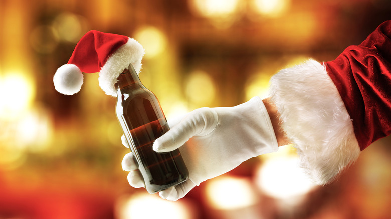 Santa Claus holding a bottle of beer with a miniature hat