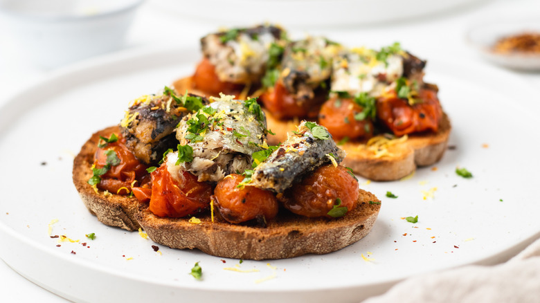 Sardine and tomato toasts on plate