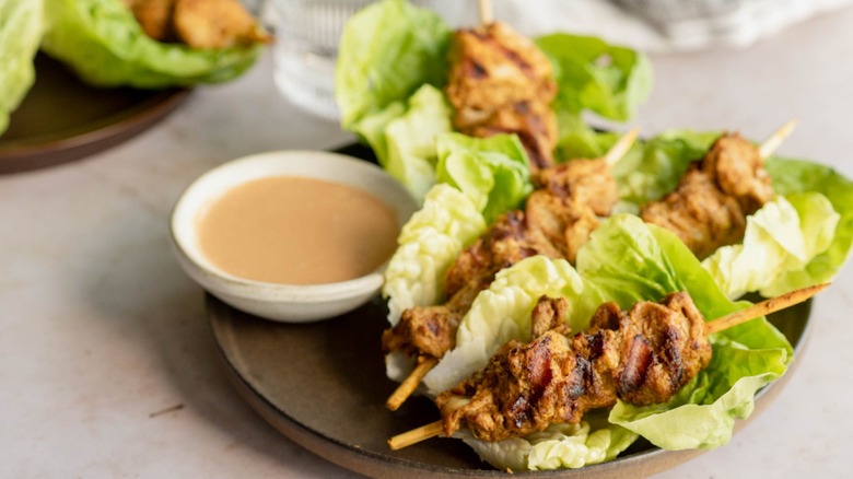 chicken on skewer in lettuce wrap on plate