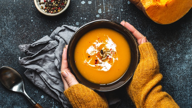 hands around soup bowl