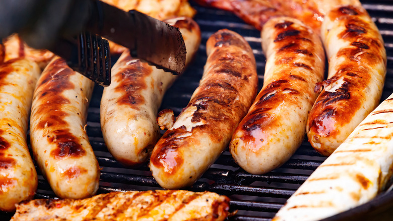 Grilling sausages with tongs