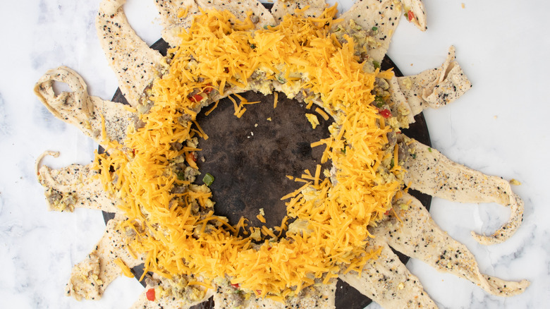 shredded cheese on crescent roll triangles