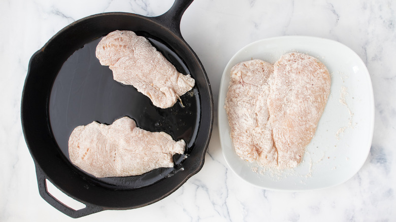 chicken breasts searing in skillet