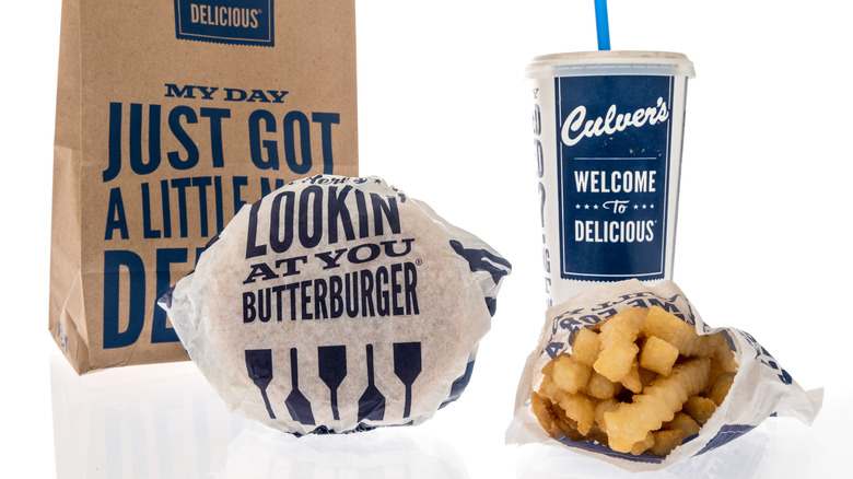 Culver's bag, wrapped hamburger, soda, and french fry bag on white background