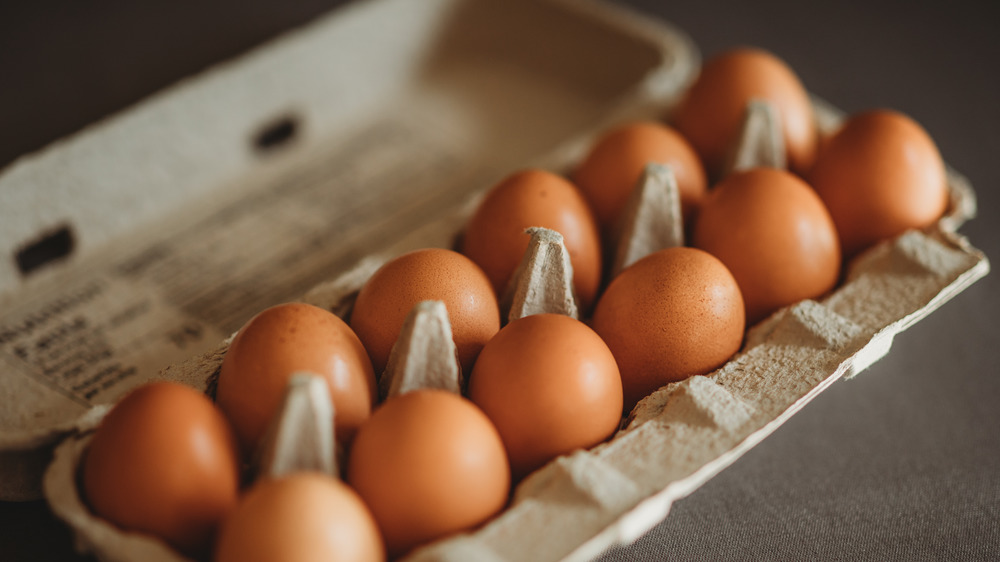 A carton of eggs on a black background