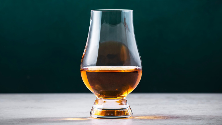 Tulip-shaped glass of brown whisky