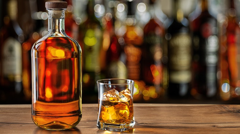 Whiskey shot and bottle on bar