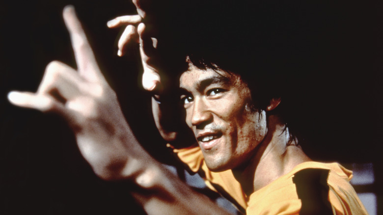 Bruce Lee wearing yellow and black "Game of Death" jumpsuit  in Kung Fu pose