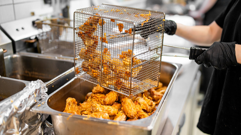 Dumping fried chicken into pan
