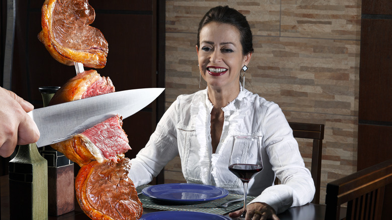Grilled picanha being carved tableside from skewer