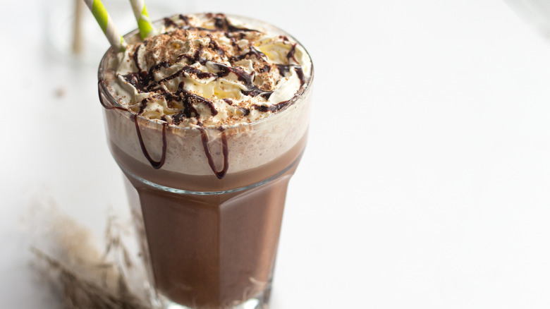 chocolate frappuccino in glass with straws and chocolate drizzle